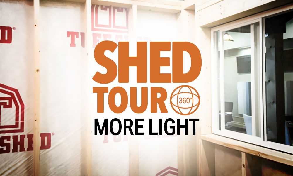 Interior of a  shed with insulation and a window, featuring the text "Shed Tour 360° More Light."