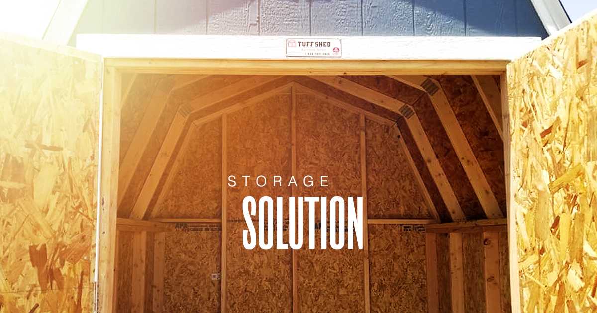 Open wooden storage shed with sunlight streaming in, showcasing spacious interior. Text overlay reads "Storage Solution."