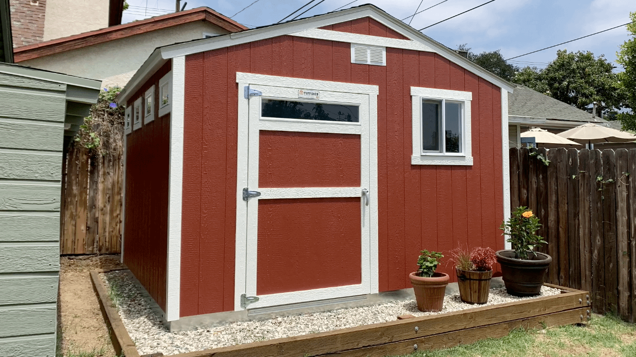 TR-700 used for storage potting plants and gardening tools. The shed is red and has pots in front of it.