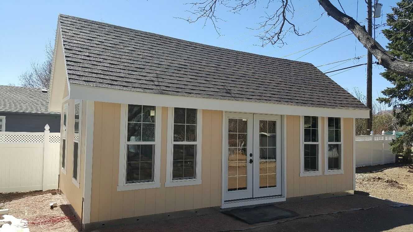 Yellow TR-800 Tuff Shed 12x24 in size exterior front with 10:12 roof pitch 12-inch overhang transom windows and upgraded french doors