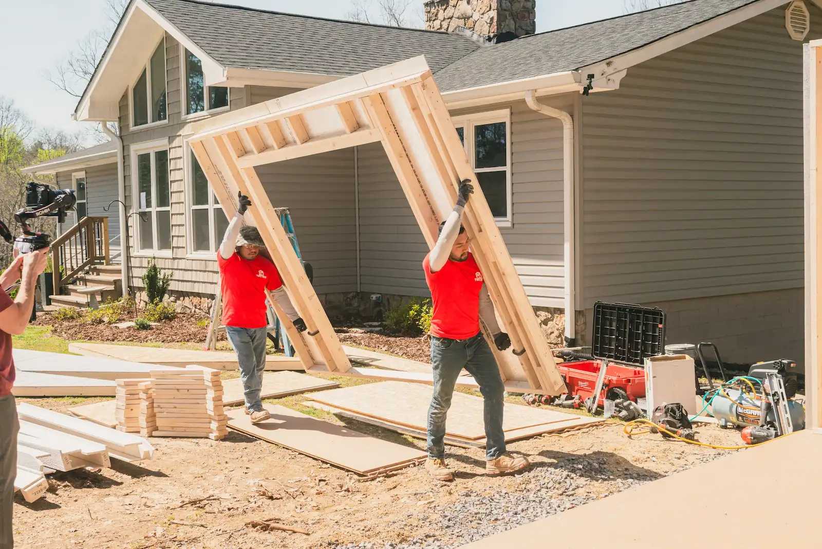 Two Tuff Shed installers carrying a wall for a Tuff Shed building