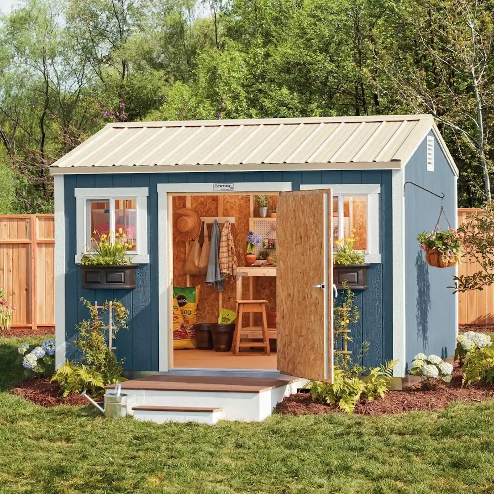 Beautiful blue TR-700 garden shed in lush backyard