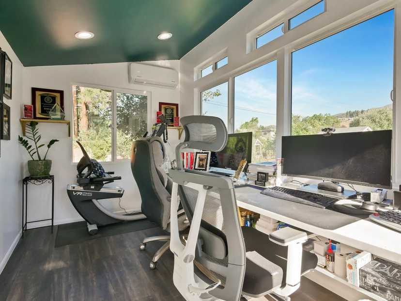 Inside view of a shed built out into a home office with two computer chairs and a plant