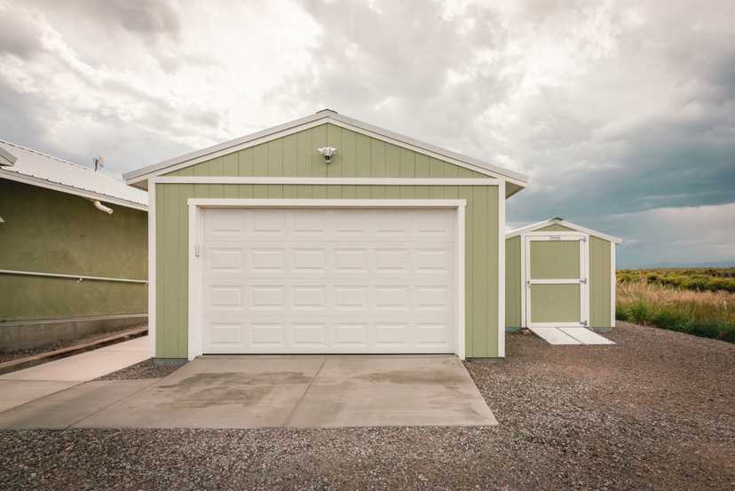A green and white tuff shed home depot garage against a cloudy sky