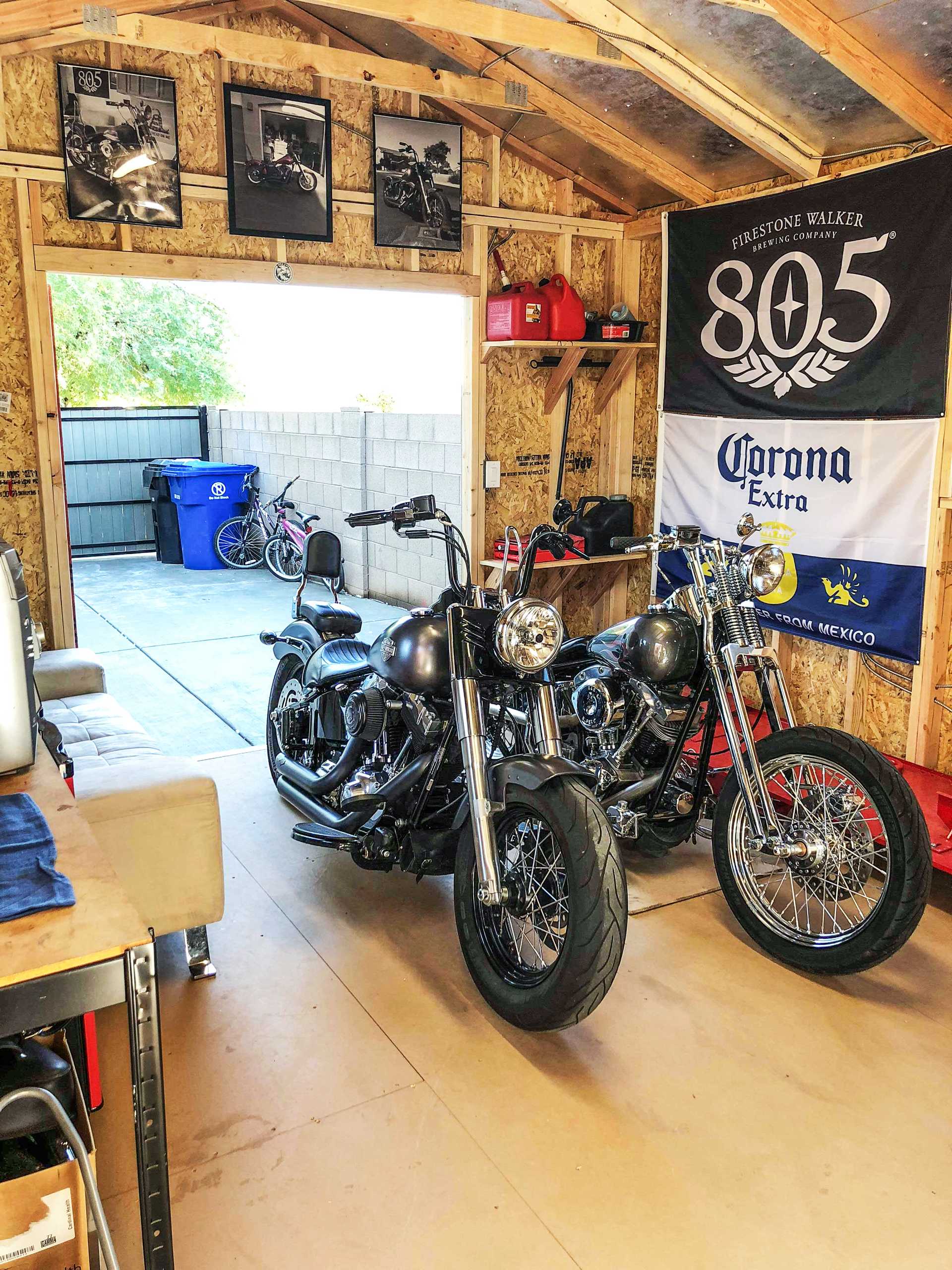 Two motorcycles in a garage with posters, and banners on the walls