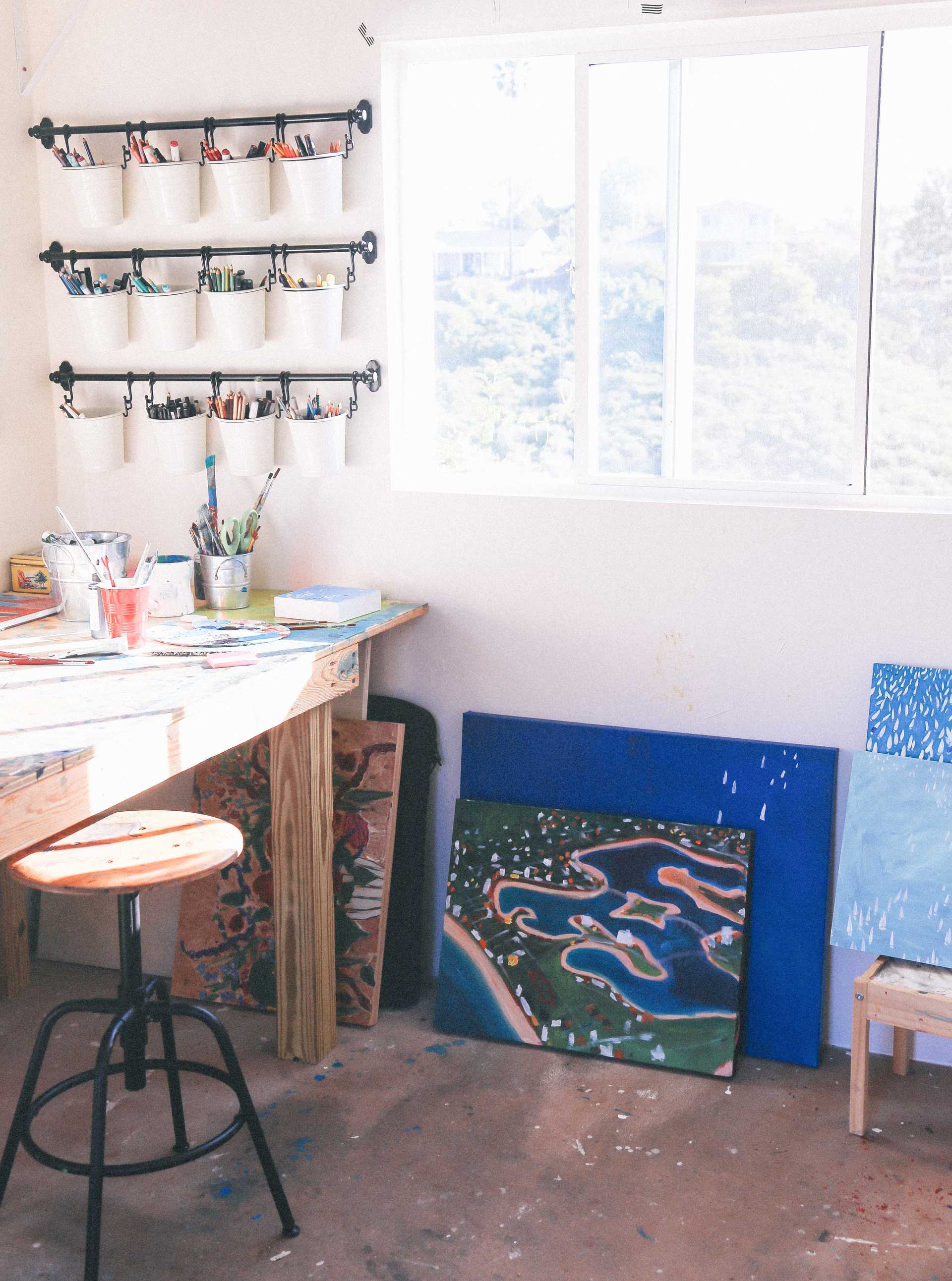 The finished TB700 art studio 2 Interior of Michaela art studio with her finished paintings on the ground and her work bench with all her art supplies on it