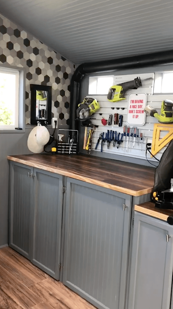 A Sundacne Lean-to being used for storage for tools.With tools on the wall.