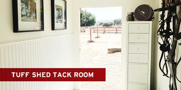 Bright tack room with white cabinets, equestrian gear, and picture frames on walls, opening to a sunny outdoor area with fences.