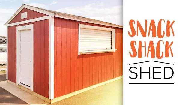 Red snack shack shed with a white door and window, set on a paved area under a clear sky
