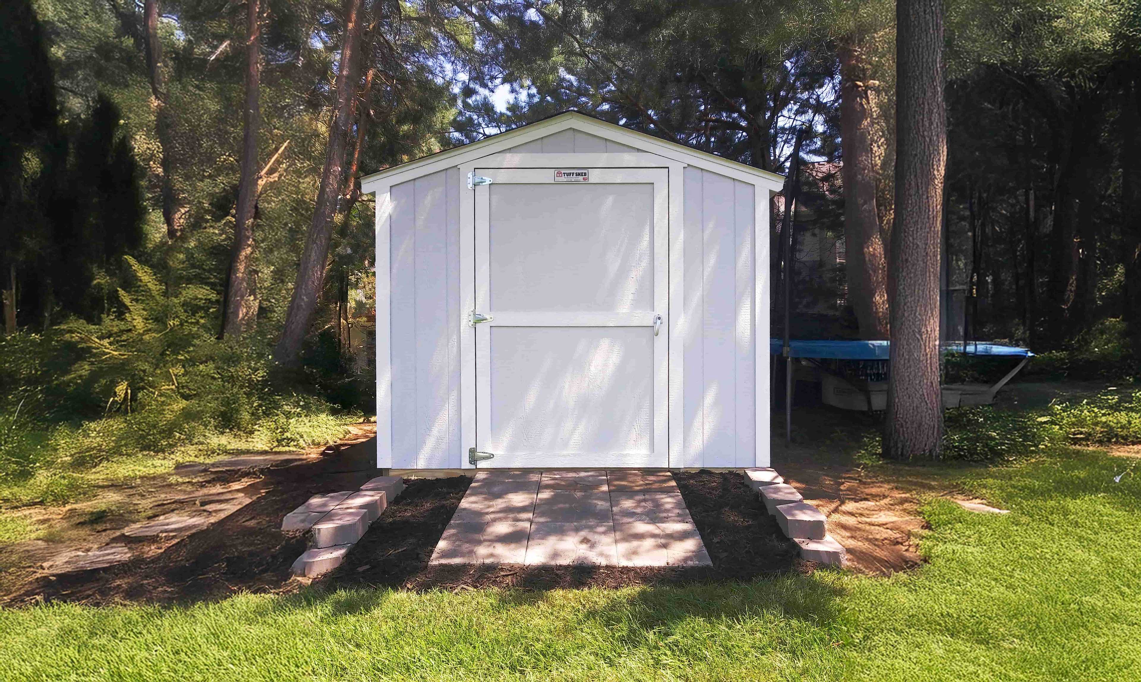 white shed in the backyard with brick landing