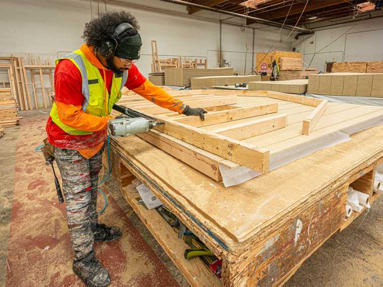 tuff shed factory worker building a wall
