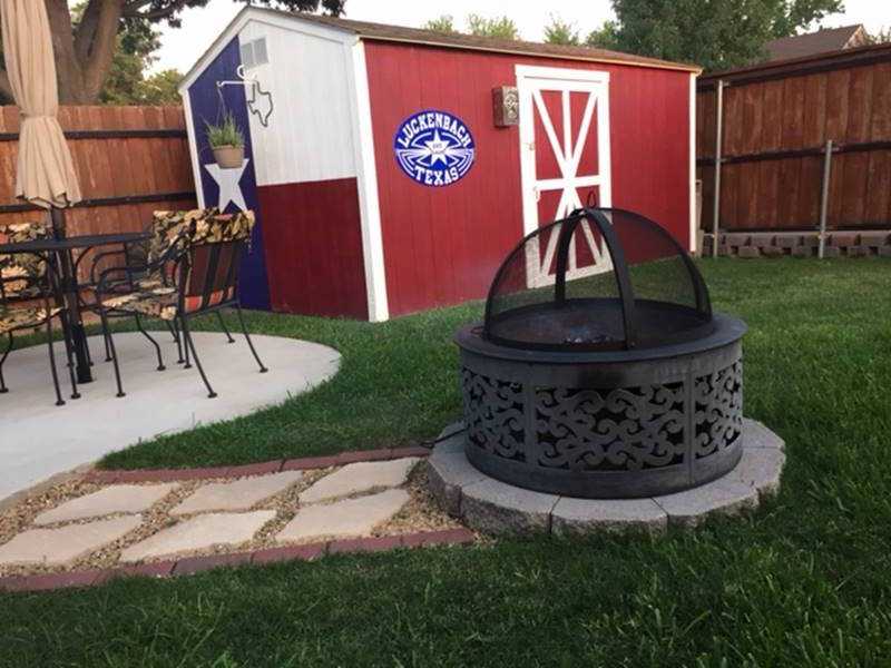 TR700 Michael's Tuff Shed building before the tornado Backyard with a fire pit, patio table, and chairs. A red and white Tuff Shed