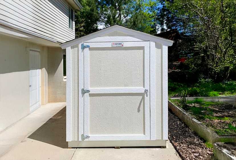 small off white shed with white trim